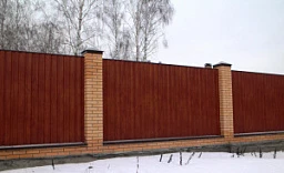 Забор на кирпичных столбах из профильного листа с рисунком под дерево